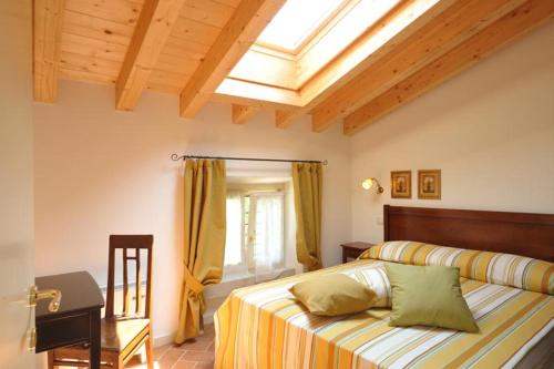 1 dormitorio con cama, escritorio y tragaluz en Le camere di Virgilio, en Monzambano