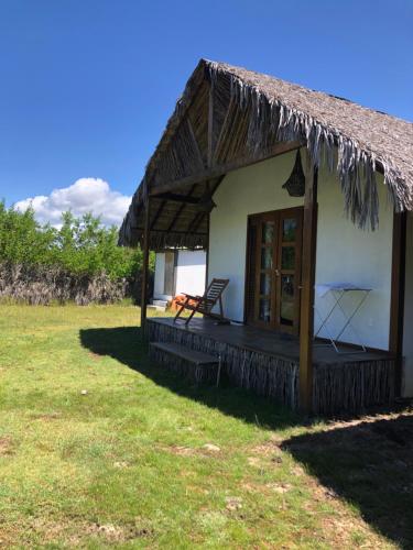 una pequeña cabaña con una silla en un campo en Tribu Chales Atins en Atins