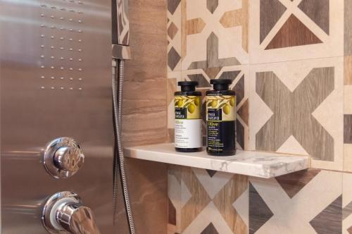 twee flessen essentiële oliën op een plank in een douche bij The Rock *Peaceful Retreat House in Kámbos