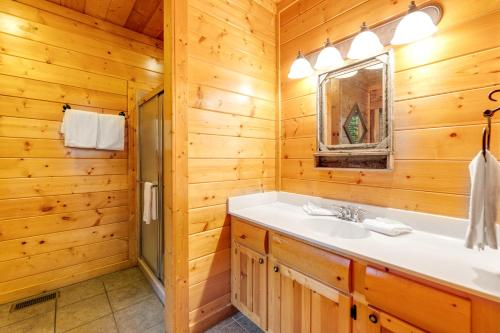 a log cabin bathroom with a sink and a shower at Valhalla Manor in Pigeon Forge