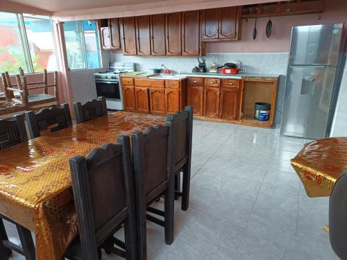 a kitchen with wooden cabinets and a table with chairs at Hospedaje Barato Mi Casita de Colores in Tijuana