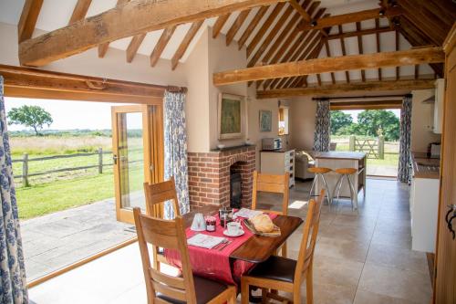 uma cozinha e sala de jantar com mesa e cadeiras em The Cowshed em Hooe