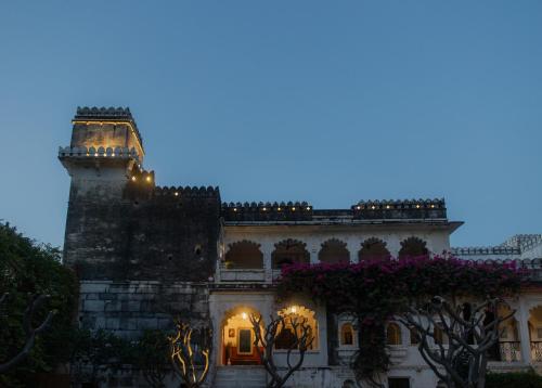 a building with a tower with flowers on it at The Rawla Narlai - A Luxury Heritage Stay in Leopard Country in Nārlāi