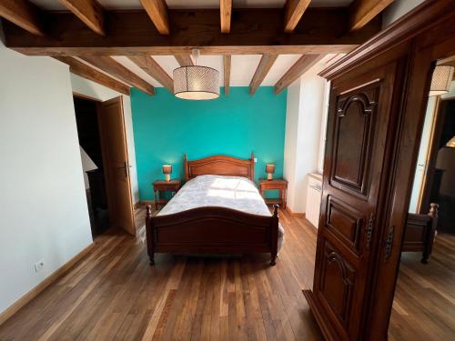 1 dormitorio con cama y pared azul en Le Mont de Piegut en Piégut-Pluviers