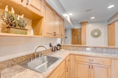a kitchen with wooden cabinets and a sink at Sea Esta 404 in Corolla