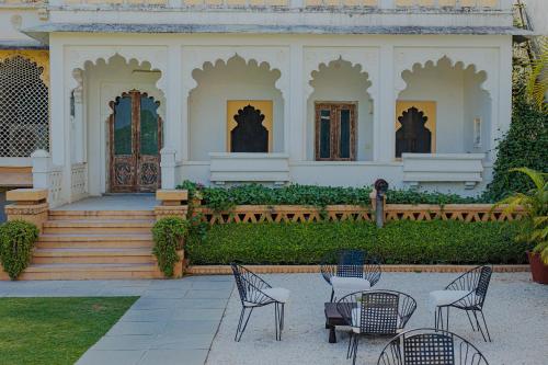 a group of chairs and tables in front of a house at The Rawla Narlai - A Luxury Heritage Stay in Leopard Country in Nārlāi