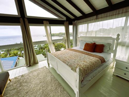a bedroom with a bed with a view of the ocean at MIRAMAR SUITES in West End
