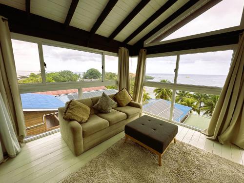 a living room with a couch and a large window at MIRAMAR SUITES in West End