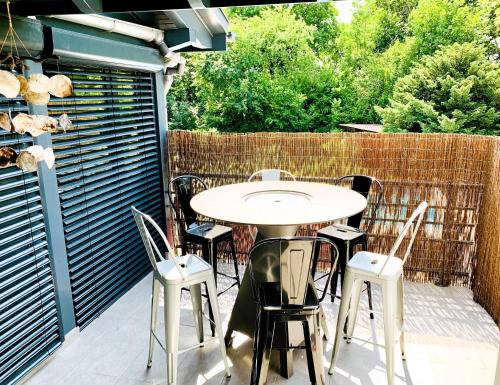a patio with a table and chairs and a fence at Aux Couleurs d'Alsace in Ostwald