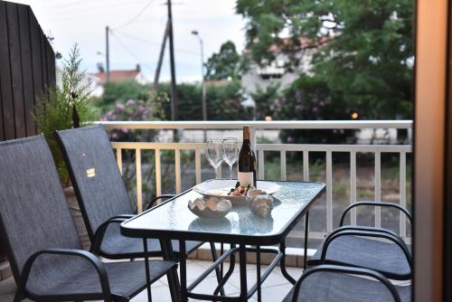 una mesa con una botella de vino y copas de vino en Holiday blue, en Palaión Tsiflíkion