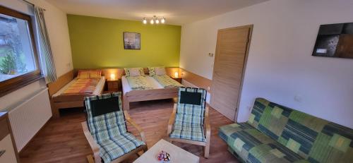 ein Wohnzimmer mit einem Sofa, einem Tisch und Stühlen in der Unterkunft Apartments Oman in Kranjska Gora