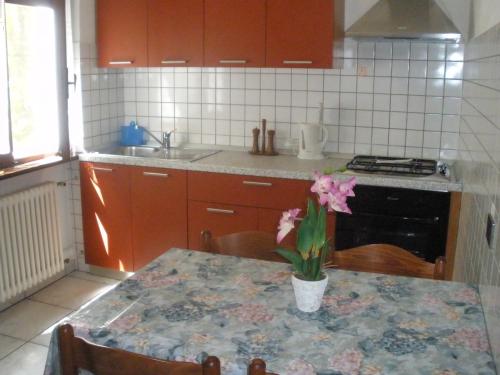 a kitchen with a table with a vase of flowers on it at Casa Variante in Cannobio