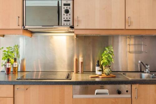 a kitchen with a sink and a microwave at Super-central and attractive Apartment in Oslo