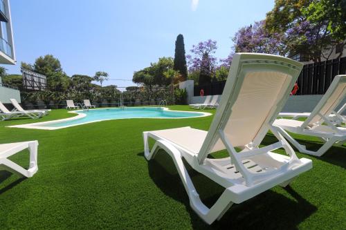 a white rocking chair sitting next to a pool at Hotel C31 in Castelldefels