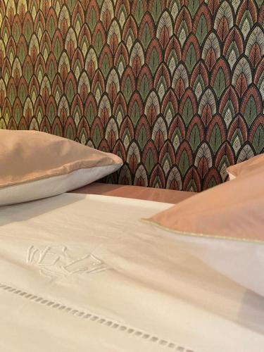 łóżko z poduszką i wzorzystą ścianą w obiekcie La Finca w mieście Nîmes
