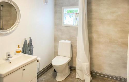 La salle de bains est pourvue de toilettes blanches et d'un lavabo. dans l'établissement Amazing Home In Frjestaden With Kitchen, à Färjestaden
