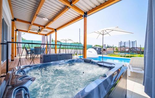 a hot tub on the patio of a house at Pet Friendly Home In Cerovacki Galovici in Galović-Selo