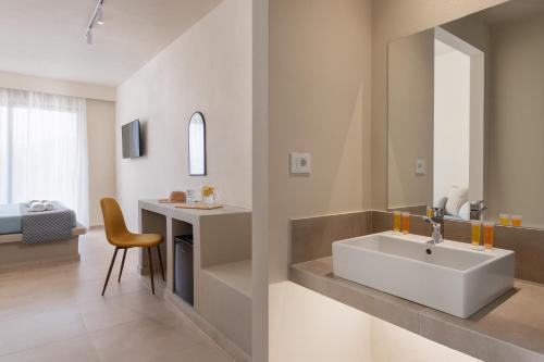 a bathroom with a sink and a bedroom at Olive Garden Hotel in Lardos