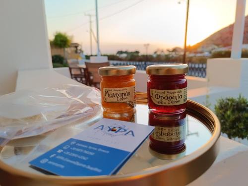 two bottles of honey sitting on top of a table at ΑΥΡΑ Ενοικιαζόμενα Δωμάτια - AVRA Rooms To Let in Galissas