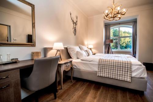 a bedroom with a bed and a desk and a mirror at Újhuta Kastélyszálló in Háromhuta