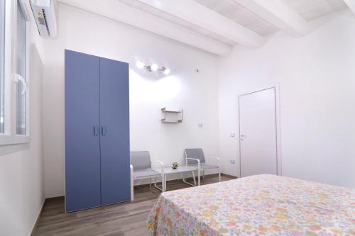 a white room with a bed and two chairs at GIGLIO DI MARE Residence in Sellia Marina