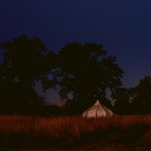 a tent in the middle of a field at night at La Prairie Étoilée Luxury Glamping - Adults Only in Crozon-sur-Vauvre