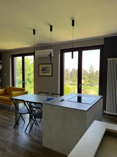 a kitchen with a table and a living room at Casetta Fausta immersa nel Golf Margara. in Fubine
