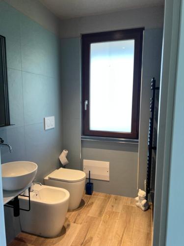 ein Bad mit einem WC, einem Waschbecken und einem Fenster in der Unterkunft Casetta Fausta immersa nel Golf Margara. in Fubine