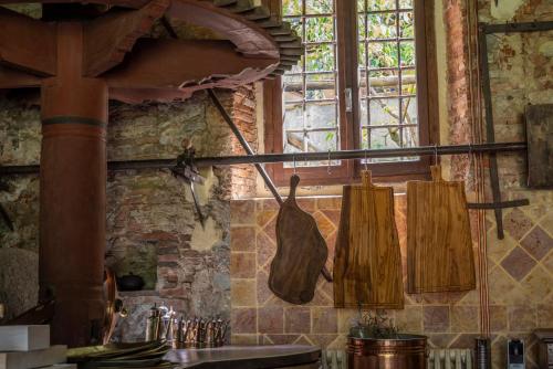 uma cozinha com utensílios de madeira pendurados na parede em Frantoio Del Moscatello em Camaiore