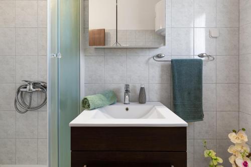 a bathroom with a white sink and green towels at Apartments Anica - Vlašići Island Pag in Vlašići