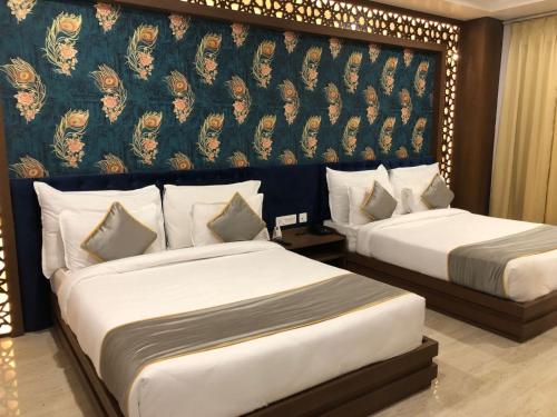 a hotel room with two beds and a wall mural at Bamboo Saa Mulberry Resort Pushkar in Pushkar