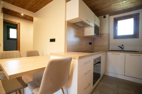 a kitchen with a wooden table and a counter top at Appartement cosy Rez-de-jardin in Demi-Quartier