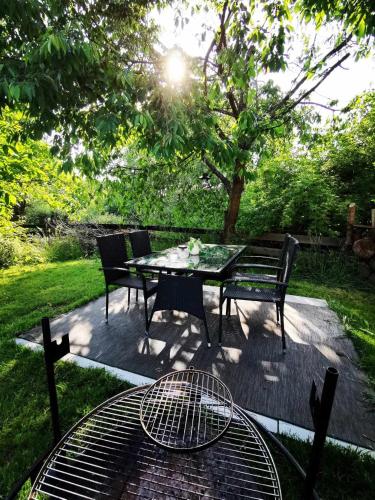 a table and chairs sitting on a patio in the grass at Romantická Chalupa Louka in Louka