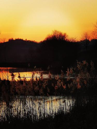 a sunset over a body of water with the sun setting at Romantická Chalupa Louka in Louka