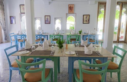 a dining room with a table and chairs at The Rawla Narlai - A Luxury Heritage Stay in Leopard Country in Nārlāi