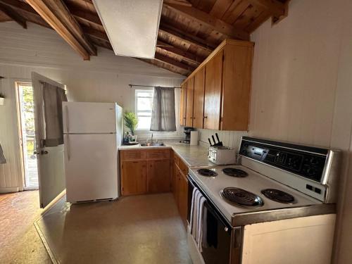 a kitchen with a stove and a refrigerator at Archie's Lakeside Cabin in Wolfville