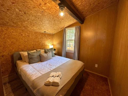 a bedroom with a bed with shoes on it at Archie's Lakeside Cabin in Wolfville