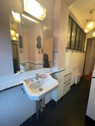 une salle de bain avec un lavabo et un miroir dans l'établissement LE MONTMORENCY 41 Authentique et Cosy Centre Historique Proximité Parking Gratuit, à Sète