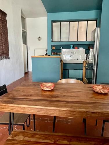 - une cuisine avec une table en bois et 2 bols dans l'établissement LE MONTMORENCY 41 Authentique et Cosy Centre Historique Proximité Parking Gratuit, à Sète