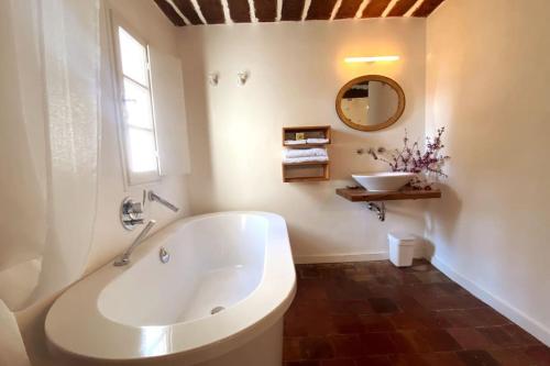 a white bathroom with a tub and a sink at Campagne du XVII au luxe simple in Lorgues