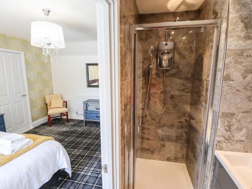 uma casa de banho com um chuveiro e um lavatório num quarto em Holly Cottage em Lincoln