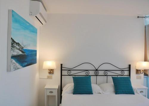 a bedroom with a bed with blue pillows at Albergo"Villa Biscotti" in Peschici