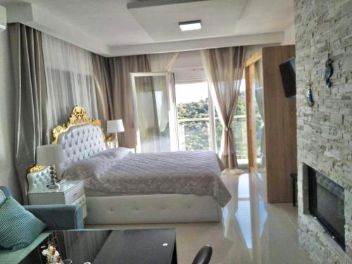 a bedroom with a king sized bed and a fireplace at Chrystal Boutique Suite in Skala Marion