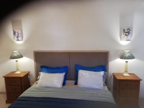 a bedroom with a bed with blue sheets and two lamps at Apartamento Saint Martin in Armação de Pêra
