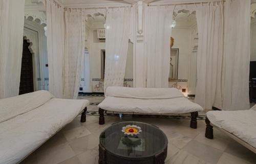 a bedroom with two beds and a glass table at The Rawla Narlai - A Luxury Heritage Stay in Leopard Country in Nārlāi