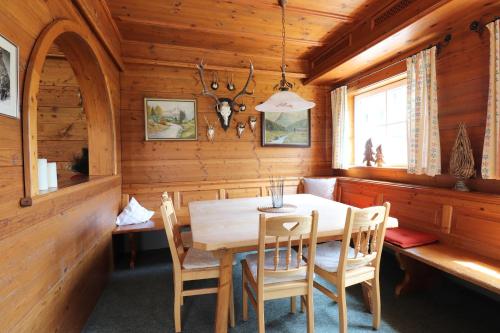 ein Esszimmer mit einem Holztisch und Stühlen in der Unterkunft Schelpenalp Berghotel Balderschwang in Balderschwang