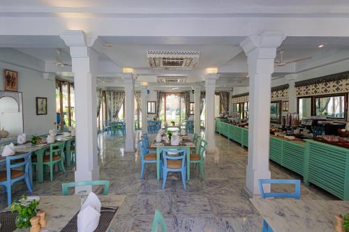 a restaurant with tables and chairs in a room at The Rawla Narlai - A Luxury Heritage Stay in Leopard Country in Nārlāi