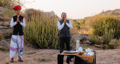 two people standing next to a table with their arms crossed at The Rawla Narlai - A Luxury Heritage Stay in Leopard Country in Nārlāi