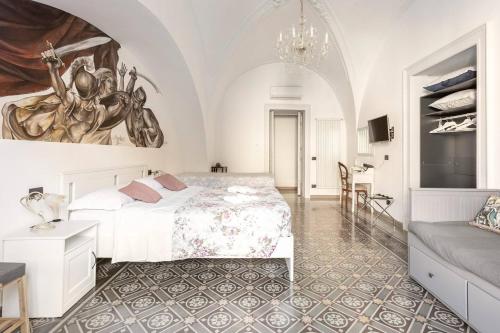 a white bedroom with a bed and a couch at Terra d'Amuri Hotel in Catania