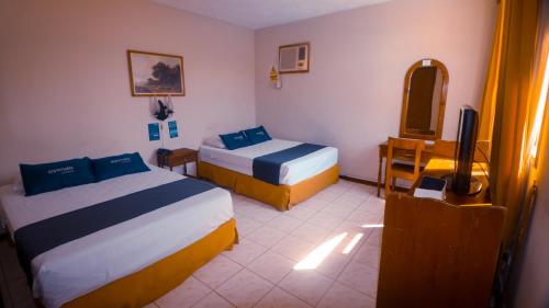 a hotel room with two beds and a television at LA SIESTA-Hotel in Sullana